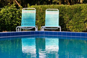 two lounge chairs by a pool