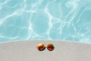 Sunglasses on concrete by swimming pool